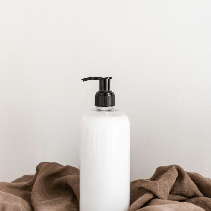 White pump cleanser bottle on draped linen